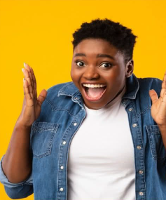 A lady smiling with her hands up in the air in excitement.
