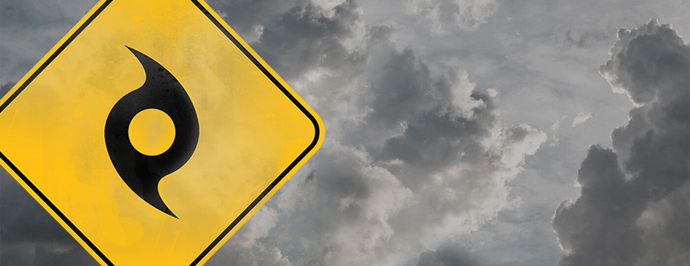 A hurricane sign behind dark clouds.