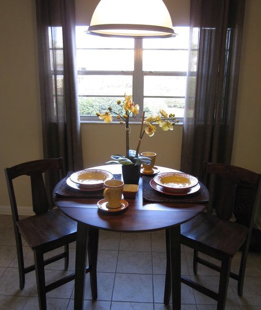 A table with a floral center piece is set for two in the one-bedroom rental.