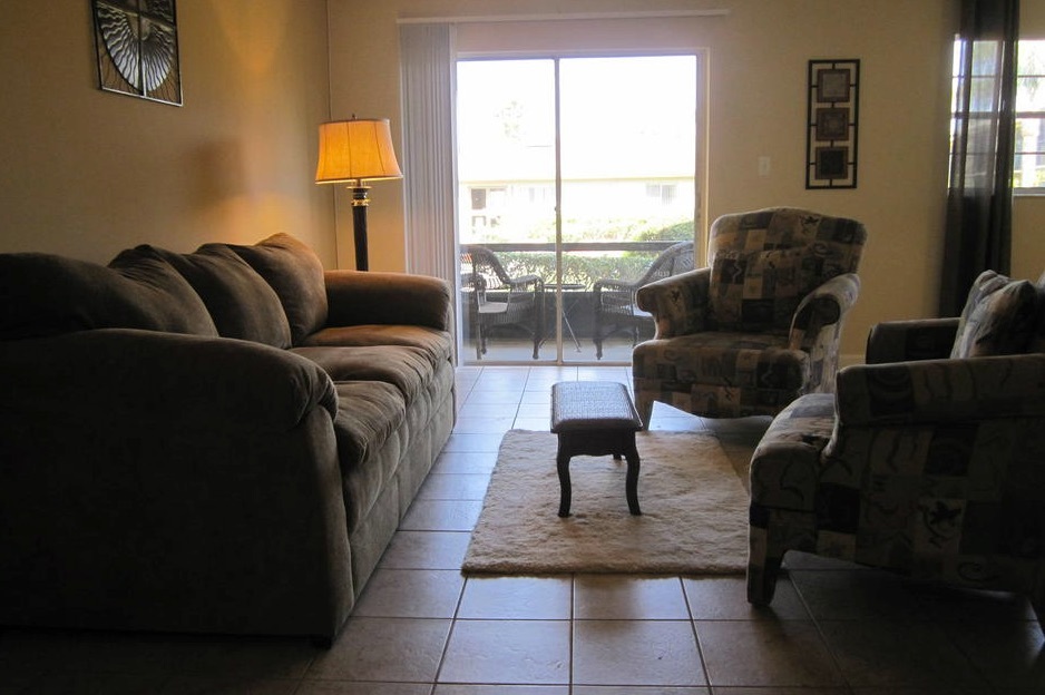 A living room space with one couch and 2 chairs facing each other in the one-bedroom rental.
