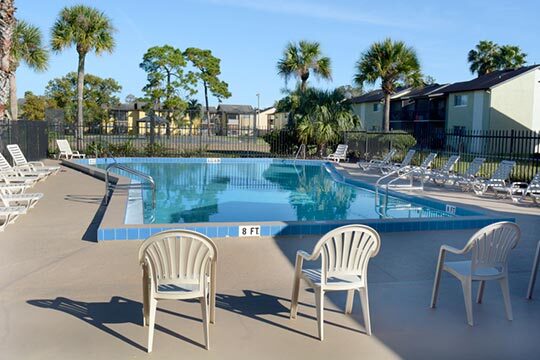 Lounge chairs line the edges of a large outdoor pool.