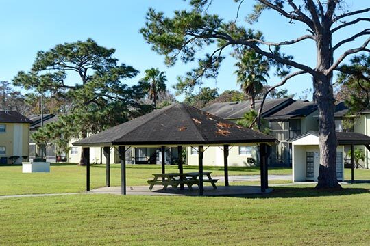 A picnic table sits underneath a pavilion outside of the Tuscany at Aloma rentals. 