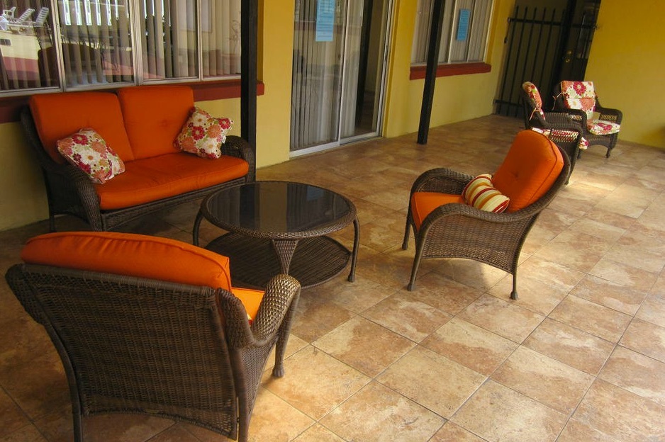A love seat sits facing two chairs with a table in the middle in this outside seating area. 