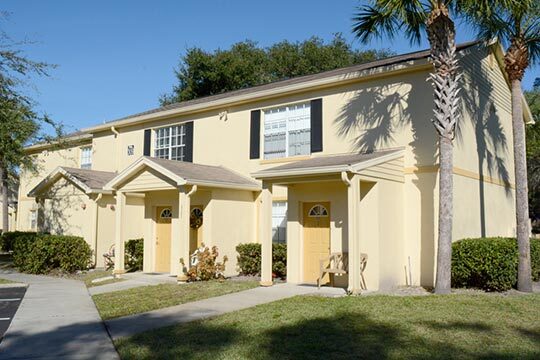 Outside, a walkway leads to the doors of the rental units. 