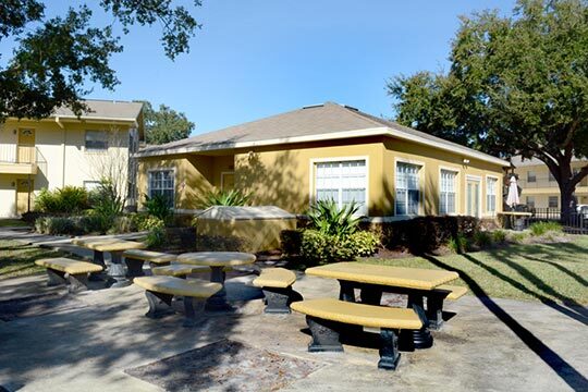 Three picnic tables sit side by side outside one of the rentals.