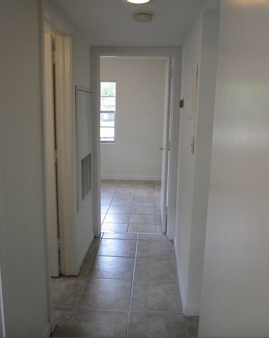An empty and tiled hallway in the three-bedroom rental.