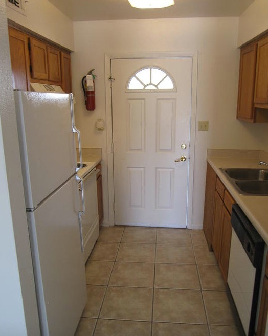 Light shines in the window of the door at the end of the kitchen in the two-bedroom rental. 