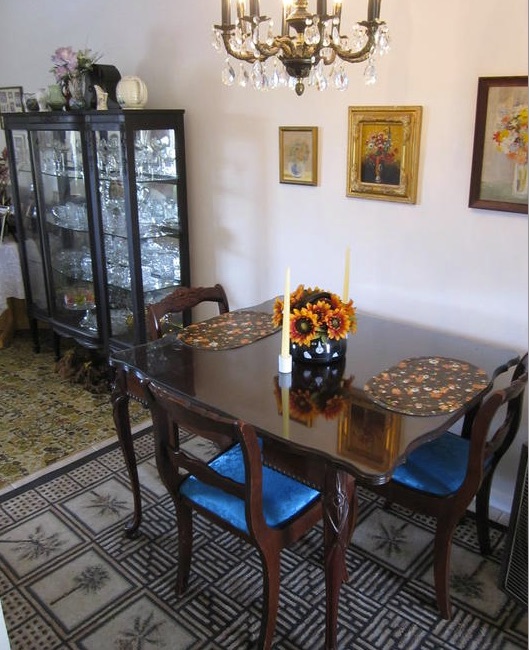 A kitchen table sits against the wall with 3 chairs pulled up to it in the one-bedroom rental. 