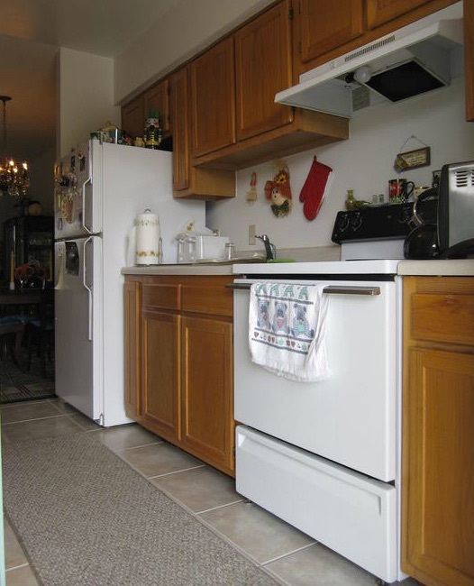 A stove, kitchen sink, and refrigerator sit in the kitchen of the one-bedroom rental.