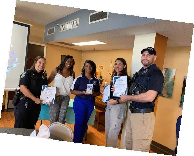 Executive Director LaShanda Lovette presenting Community Partner pin to Winter Park Police Officers