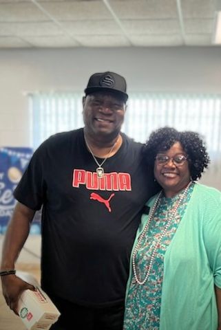 A man and woman stand and smile for a picture.