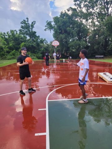 Kids playing basketball on a wet court.