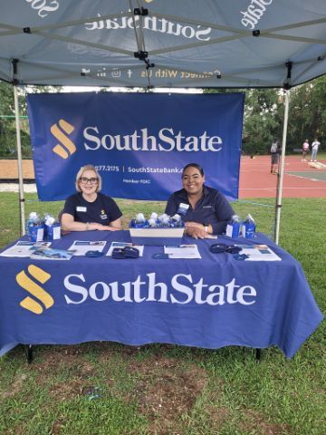 Two women smiling at the South State Bank tent.