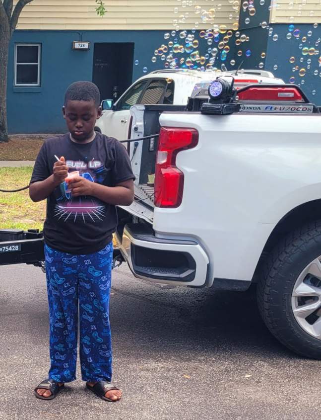 A kid standing and eating a frozen treat!