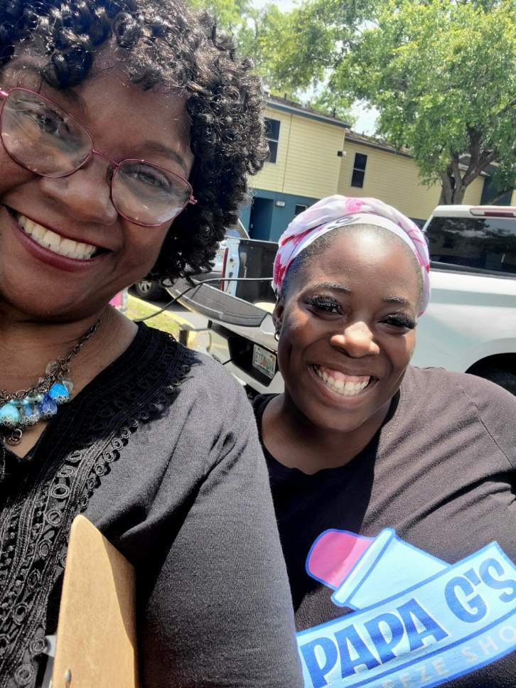 Two women standing and smiling for a selfie.