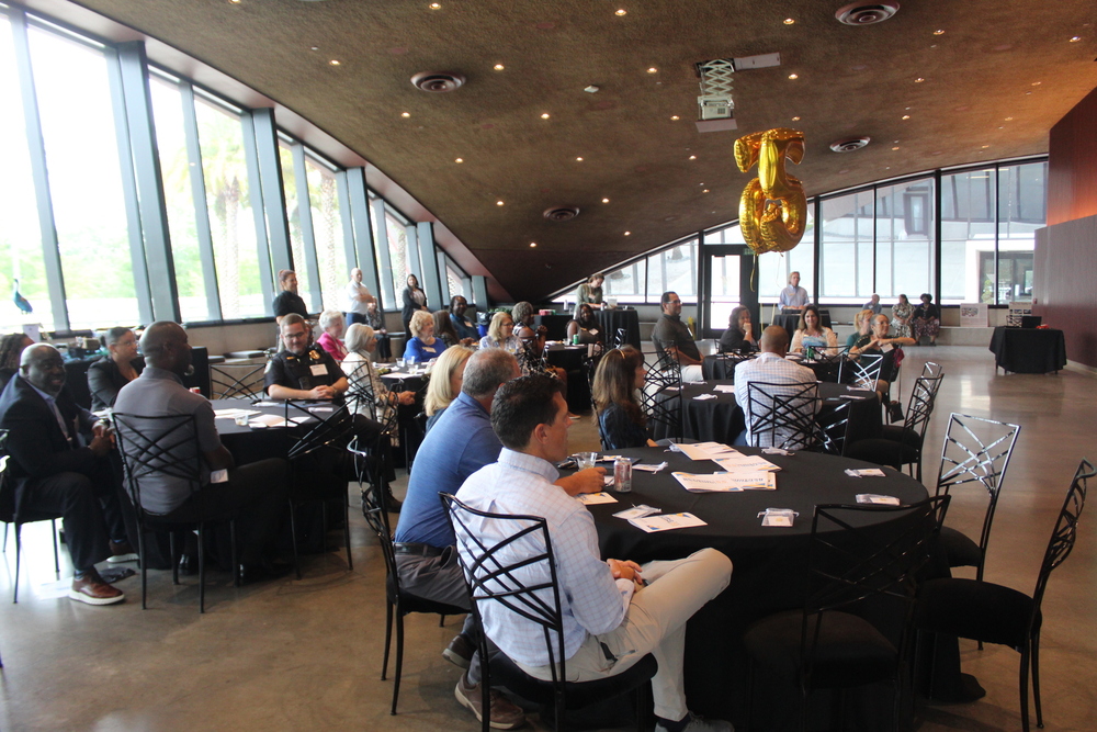 A room full of people sitting at tables.