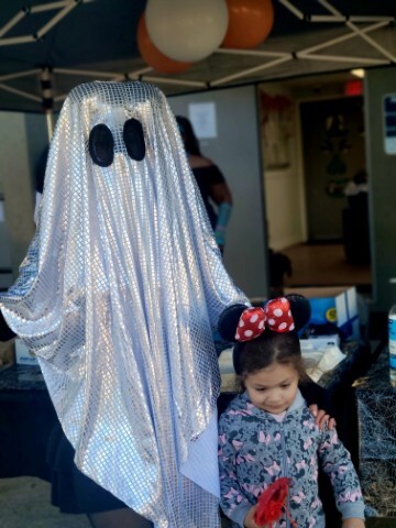 A ghost poses with a young girl dressed as a Mouseketeer. 