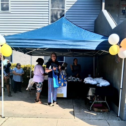 People in line under a pavillion getting food.