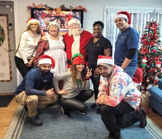 Seven people smiling for a photo with Santa.