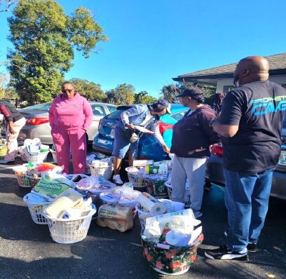 People standing in the parking lot with gift baskets.