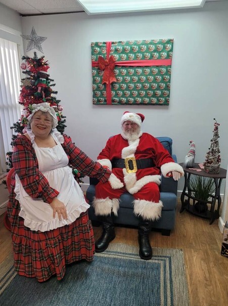 Santa and Mrs. Clause sit and smile for a picture.